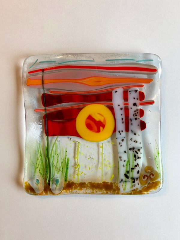 A glass tile featuring an abstract forest with a red sky.
