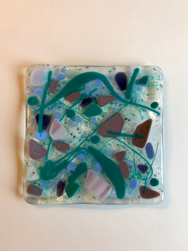 A glass tile featuring blue and pink swirl.