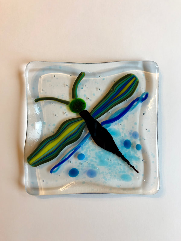 A glass tile featuring a dragonfly.