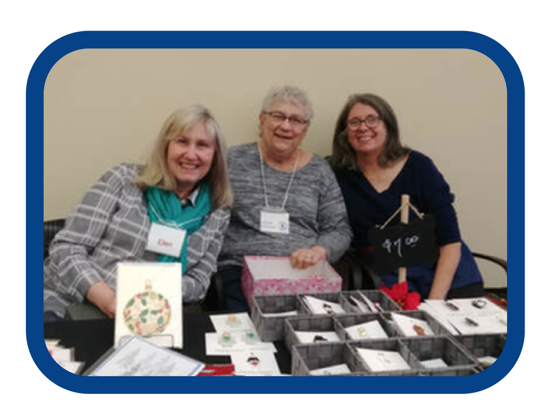 A picture of Linda Bateman, the recipient of the 2019 Volunteer Appreciation Award seated with friends.