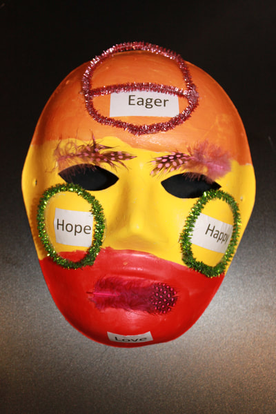Heather - The colors on the mask are red for “love”, yellow for “happy” and “hope”, and orange is for “eager”.
