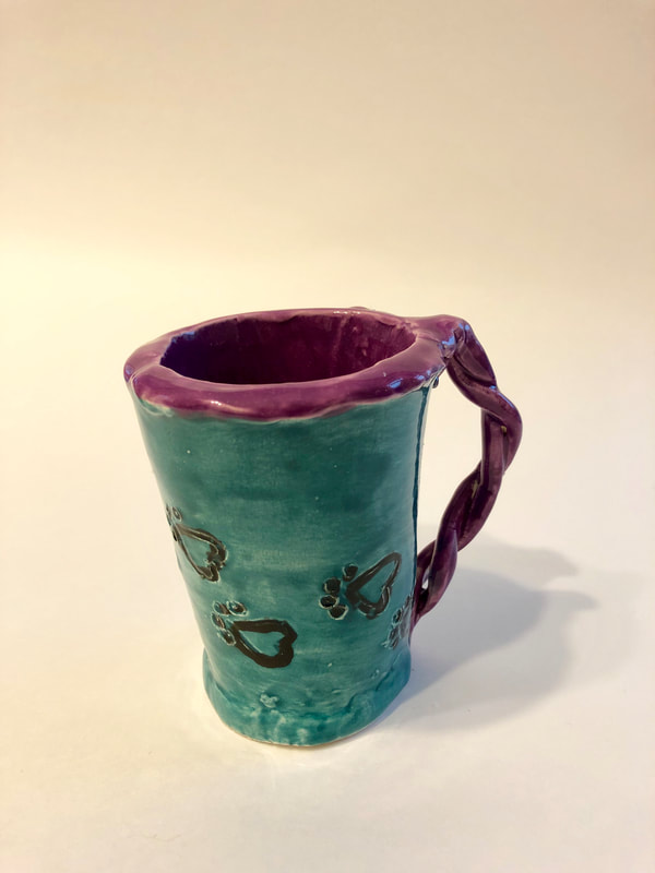 A mug featuring teal and purple designs.