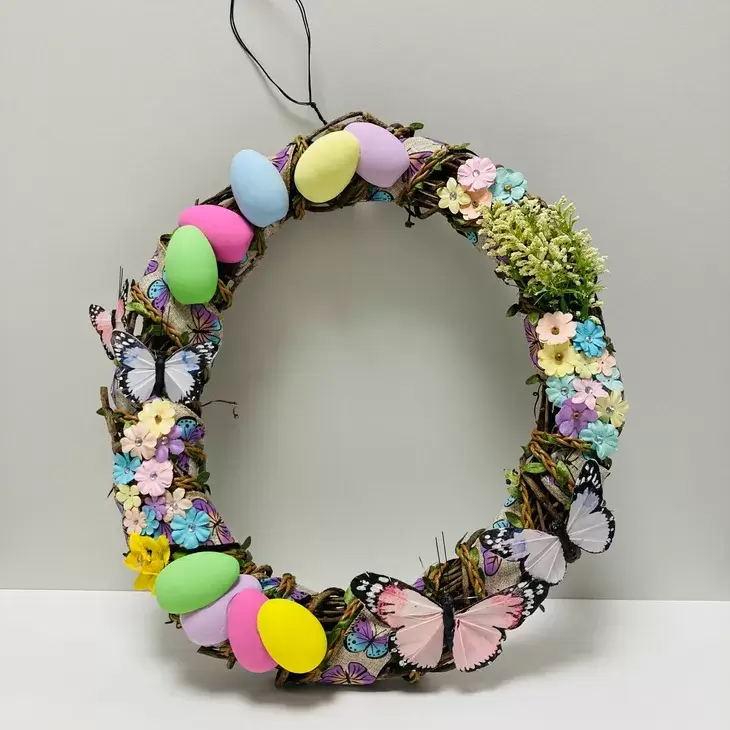 An Easter wreath featuring eggs and flowers.