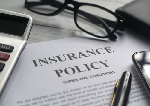 Insurance policy and glasses on a table